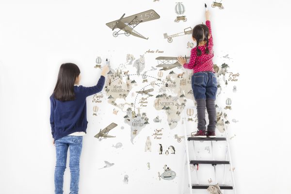 two kids drawing on the blank white wall